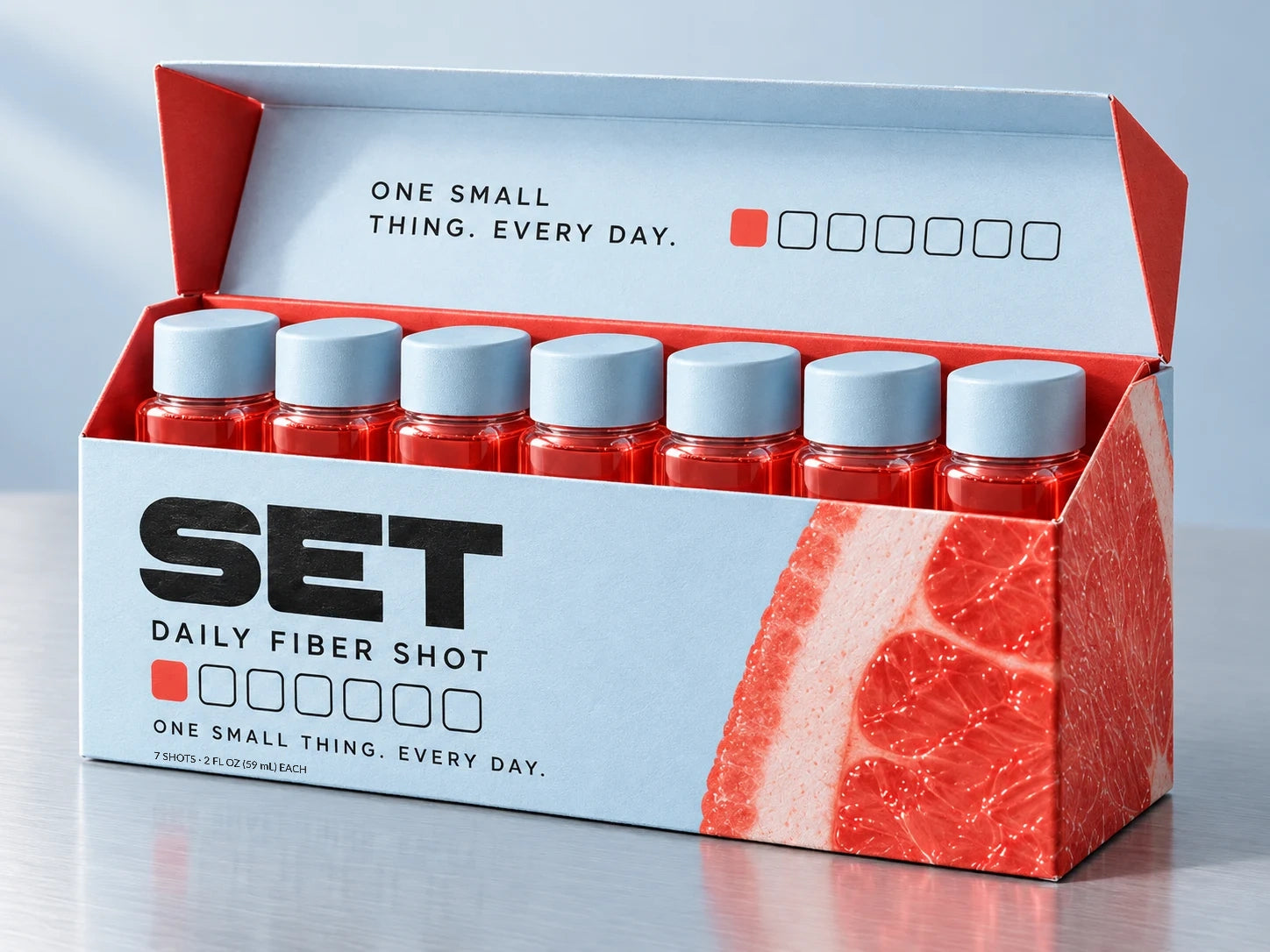 SET's original pale-blue seven-day carton with seven coral-juice shots, matte blue caps and a daily tracker, with small serving-size lettering printed below One Small Thing Every Day